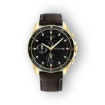 Gold-tone chronograph watch with a black dial, brown leather strap, and minimalist hour markers. Features sub-dials and branding.