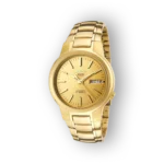 Aranyszínű Seiko 5 SNKA10K1 automata óra, hétfőt és napot jelző ablakkal, fémszíjjal, sötét háttéren.