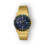 Arany színű Timex karóra, sötétkék számlap csillagokkal, zöld számokkal és szíjjal. Modern, elegáns dizájn, quartz mechanizmus.
